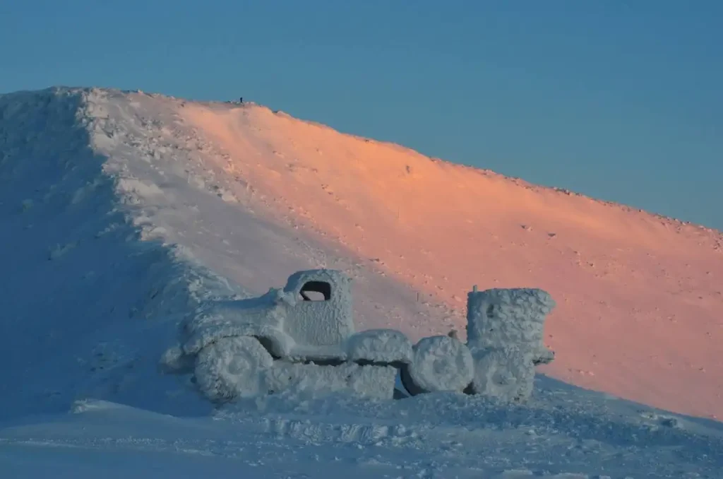 Заброшенный грузовик, занесённый снегом, в зимнем пейзаже Кольского полуострова
