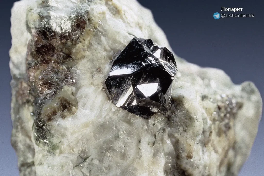 Макросъемка кристалла лопарита. Черный блестящий минерал с металлическим отливом, кристаллизовавшийся в белой породе