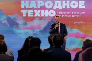 Борис Курцев выступает на конференции 'Народное Техно' перед аудиторией, на фоне большого экрана с надписью Народное Техно.