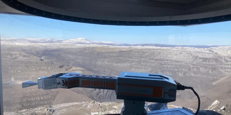 Георадар на разрезе «Нерюнгринский» в Якутии, установленный для мониторинга горного массива, с видом на карьер и заснеженные склоны, обеспечивает безопасность работников