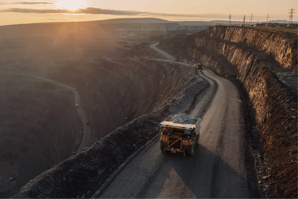 Карьер Олимпиада: крупнейшее золоторудное месторождение в Красноярском крае. Вид на террасированные уступы и карьерные самосвалы, перевозящие руду