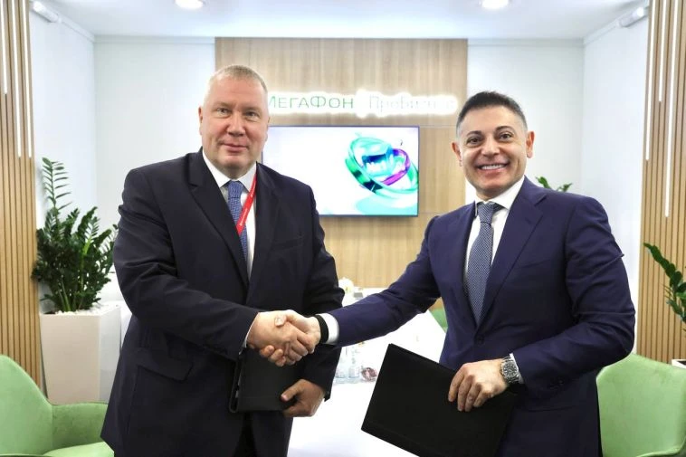 Руководители ММК и МегаФона пожимают руки после подписания соглашения о создании цифрового склада угля для оптимизации управления сырьем.