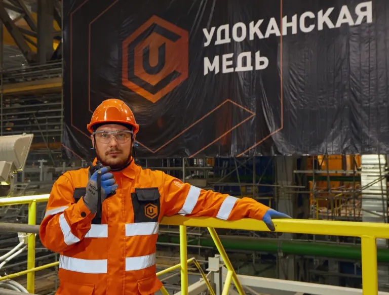 Сотрудник в спецодежде на производственной площадке компании «Удоканская медь», где открыты вакансии инженеров с привлекательными условиями работы на крупнейшем медном месторождении России