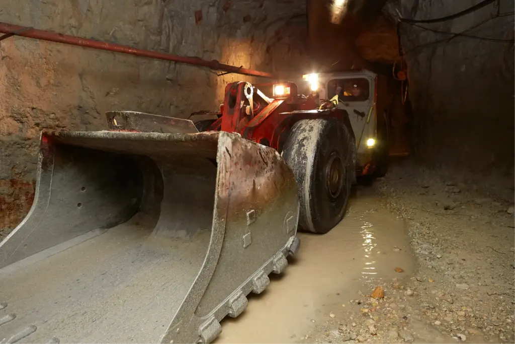 Погрузчик транспортирует горную массу в подземной выработке рудника Удачный