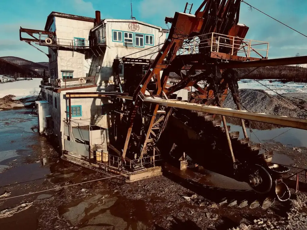 Плавучая драга на россыпном золоторудном прииске в Сибири